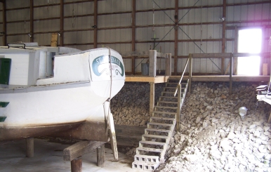 A work platform beside the stanchions and cement pad under the canal boat greatly aid maintenance efforts